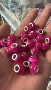 Macro view of bright pink cat's eye style beads with large silver core holes for DIY