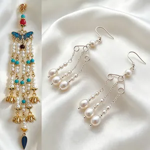 Elegant handmade pearl tassel drop earrings and butterfly pendant on white silk background