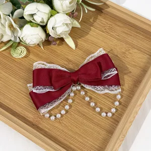 Elegant red Lolita bow hair clip featuring white lace trim and delicate pearl chain details