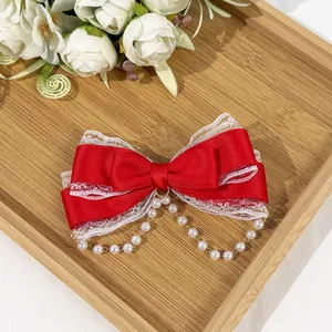 Detailed view of red Lolita bow hair clip featuring white lace and pearl chain