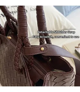 Close-up of brown woven leather bag with detachable shoulder strap detail
