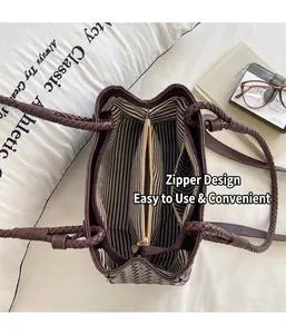 Detailed top view of a brown woven handbag with striped lining and central zipper
