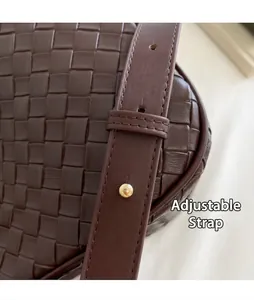 Close-up detail of the adjustable strap and woven leather texture on brown bag