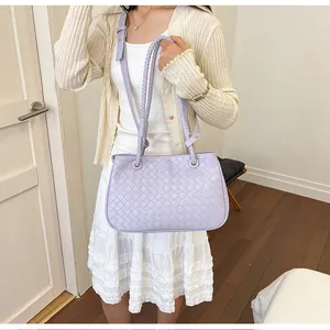 Detailed lifestyle shot of a lavender woven texture shoulder bag styled with a white outfit