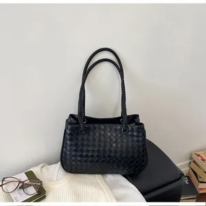 Detailed view of a black woven bucket bag on a minimalist white background