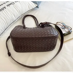 Detailed view of the dark brown woven leather handbag with adjustable strap