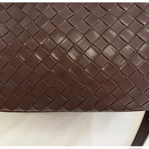 Macro detail of dark brown woven leather texture for stylish crossbody bucket bag