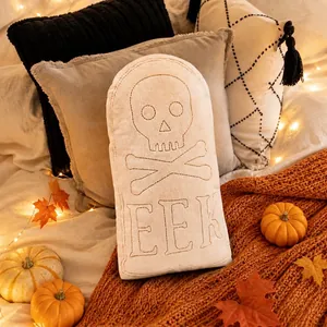 Halloween tombstone shaped plush pillow featuring embroidered skull and EEK word decoration