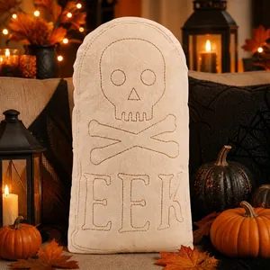 Close-up of Halloween tombstone plush pillow with embroidered skull and EEK lettering