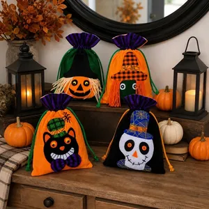 Vista dettagliata di quattro sacchetti per caramelle di Halloween in velluto su tavolo in legno.