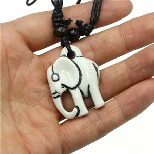 Detail van witte hars olifant hanger ketting met imitatie bot afwerking en houten kralen accenten.
