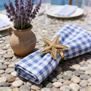 Golden metal starfish napkin ring from the ocean series on a checkered napkin