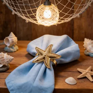 Elegant golden starfish metal napkin ring on a blue fabric with coastal sea shell decor