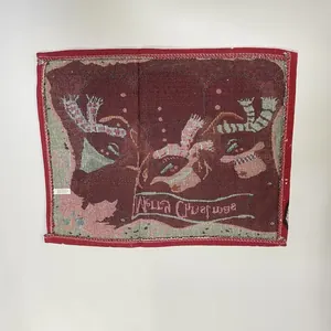 Detail view showing the back texture and care label of a red Christmas knitted placemat.