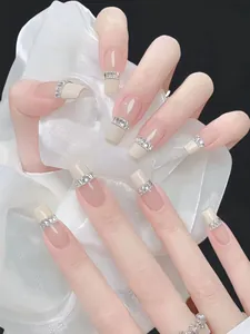 Detail of elegant press-on nails with silver rhinestone ring and nude French tips