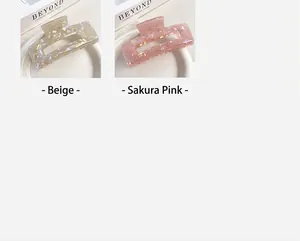 Detail view of iridescent mermaid shark clips in beige and cherry pink colors.
