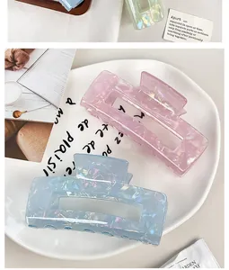 Close-up detail of large iridescent mermaid hair claw clips in pink and blue acetate