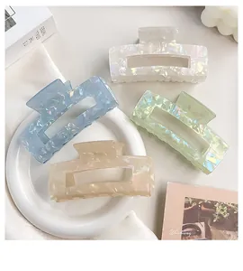 Detailed shot of four iridescent mermaid-style rectangular hair claw clips in pastel tones