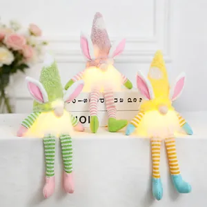 Close-up of three light-up Easter gnomes with bunny ears and long legs as decorations