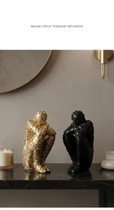 Detail of golden and black mosaic abstract thinker sculptures in elegant room decor