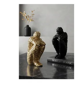 Close-up of modern abstract mosaic human sculptures in gold and matte black finishes