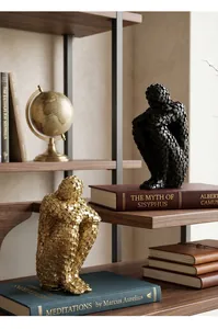 Close-up of abstract seated figure sculptures with block texture in a library setting