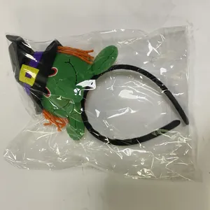 Halloween green witch plush doll headband shown in clear plastic packaging detail