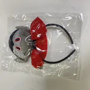 Detail view of a Halloween vampire plush headband in its transparent packaging bag