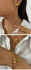Vue détaillée d'un ensemble de bijoux en forme de nœud doré avec collier et bracelet.
