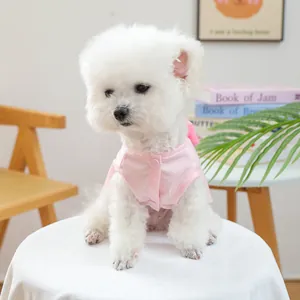 Nahaufnahme eines weißen Hundes in einer süßen rosa ärmellosen Weste mit Schleife