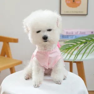 Rosa ärmellose Haustierjacke mit niedlicher Schleife an weißem Hund