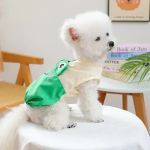 Süßer weißer Bichon-Hund trägt eine grün-cremefarbene ärmellose Haustierweste zu Hause.