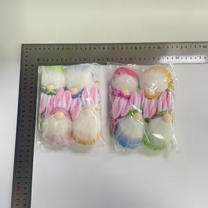 Detalle de primer plano de 4 gnomos de Pascua con regla para referencia de tamaño