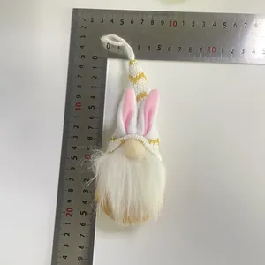 Gnomo de Pascua tejido con orejas de conejo y barba blanca medido con una regla de metal