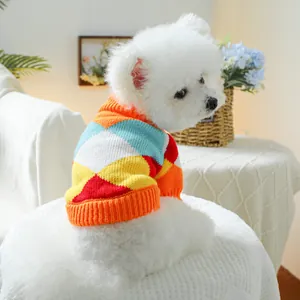 Primer plano de un suave suéter para mascotas con estampado de rombos en un perro blanco
