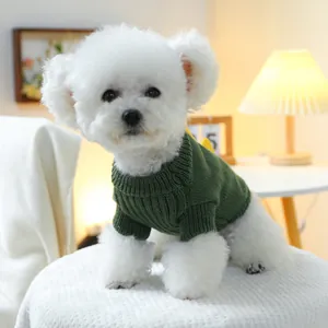 Primer plano detallado de un suave suéter de punto verde oscuro para perro en un cachorro blanco