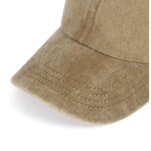 Detail van de stiksels op de gebogen klep van een gewassen kaki katoenen pet
