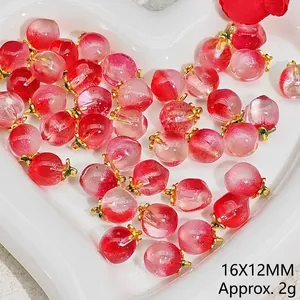 Detailed view of crystal peach charms for DIY jewelry featuring realistic gradient pink tones