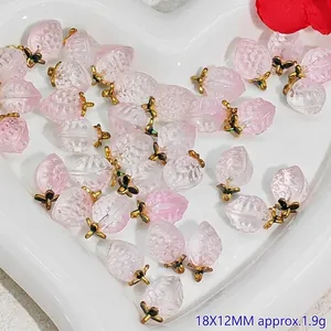 Macro view of 18x12mm pink crystal peach charms on a white heart-shaped tray