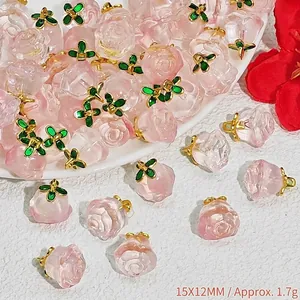 Detailed close-up of pink crystal rose charms with green leaves for DIY jewelry making
