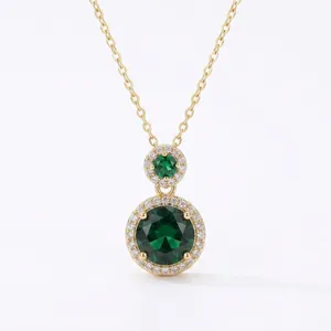 Elegant retro gold-tone necklace with two round emerald green crystal pendants.