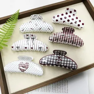 Detail view of stylish hair claw clips with plaid, polka dot and heart pattern designs