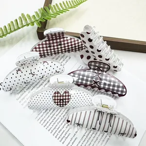 Collection of patterned hair claw clips with heart and grid designs on white paper