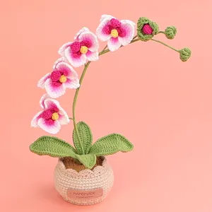 Handgehäkelte rosa Orchidee in einem beige geflochtenen Topf für die Heimdekoration