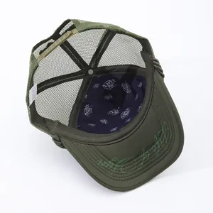 Detailed interior view of dark green mesh trucker hat with logo pattern lining