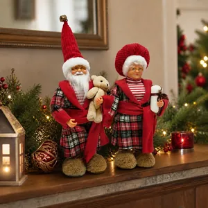 Close-up detail of standing Santa and Mrs. Claus dolls in cozy red plaid pajamas