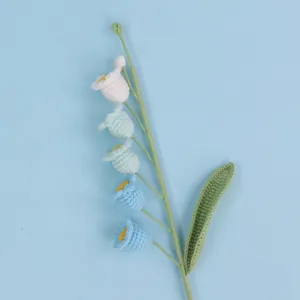 Macro detail of handmade crochet lily of the valley with blue gradient flowers