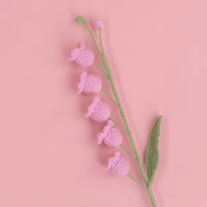 Detail of handmade crochet lily of the valley flowers with pink yarn on pink background