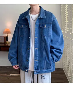 Dettaglio di una giacca di jeans blu ampia da uomo indossata con pantaloni sportivi