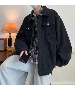 Vista dettagliata di una giacca di jeans nera oversize da uomo in un set lifestyle.